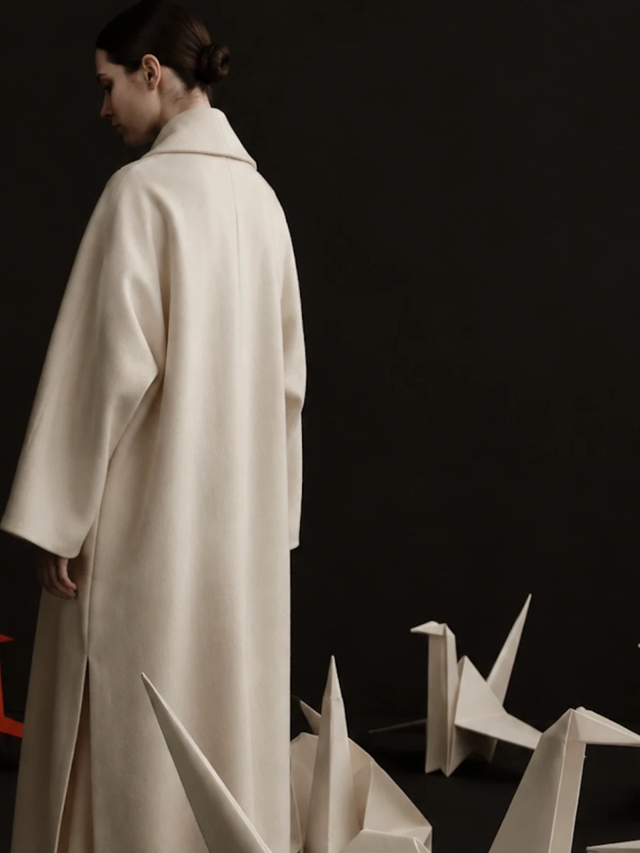 The back of the coat — seam and slit, cranes at the hem